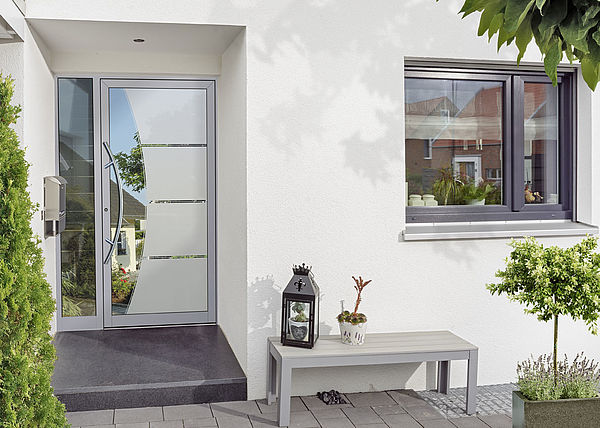 Sehen, aber nicht gesehen werden, das können Sie mit dem Design-Glas Magic jeden Tag erleben. Die Postbotin steht vor Ihrer Haustür und sieht nur sich selbst. Sie kann nicht ins Haus hineinsehen. Sie selbst hingegen können die Postbotin gut erkennen. Foto: F&R Haustürfüllungen GmbH, gesehen bei Brüggemann GmbH
